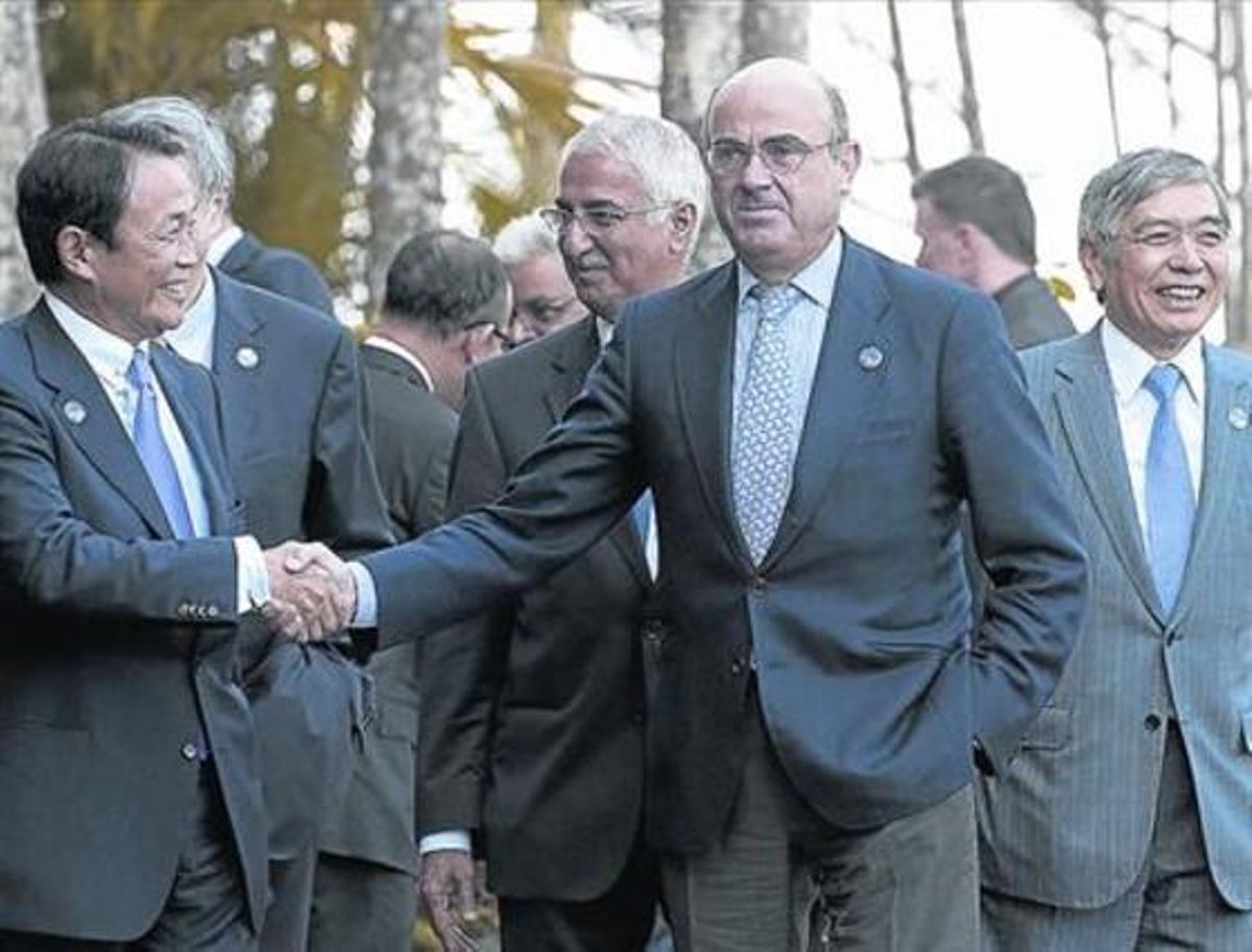 El ministro Luis de Guindos (centro) saluda al ministro de Finanzas japonés, Taro Aso, el sábado en Cairns. El ministro Luis de Guindos (centro) saluda al ministro de Finanzas japonés, Taro Aso, el sábado en Cairns.