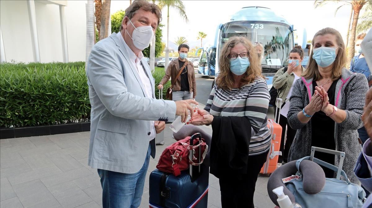 Unas turistas holandesas se frotan las manos con gel hidroalcohólico a su llegada al hotel de Maspalomas. Unas turistas holandesas se frotan las manos con gel hidroalcohólico a su llegada al hotel de Maspalomas.