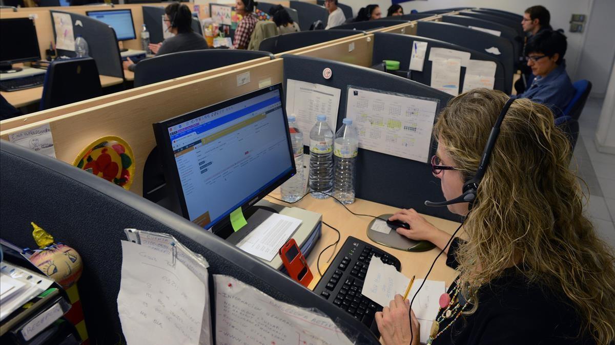Una mujer atiende llamadas en su puesto de trabajo de atención al cliente
