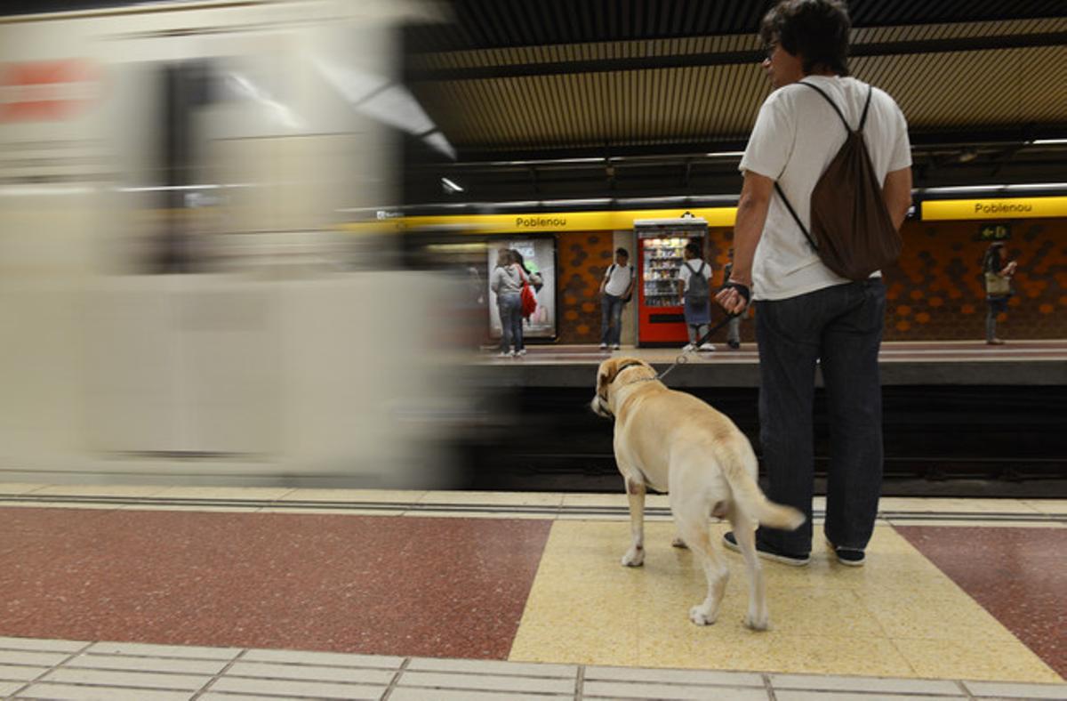 Un joven con su perro en el metro de Barcelona.