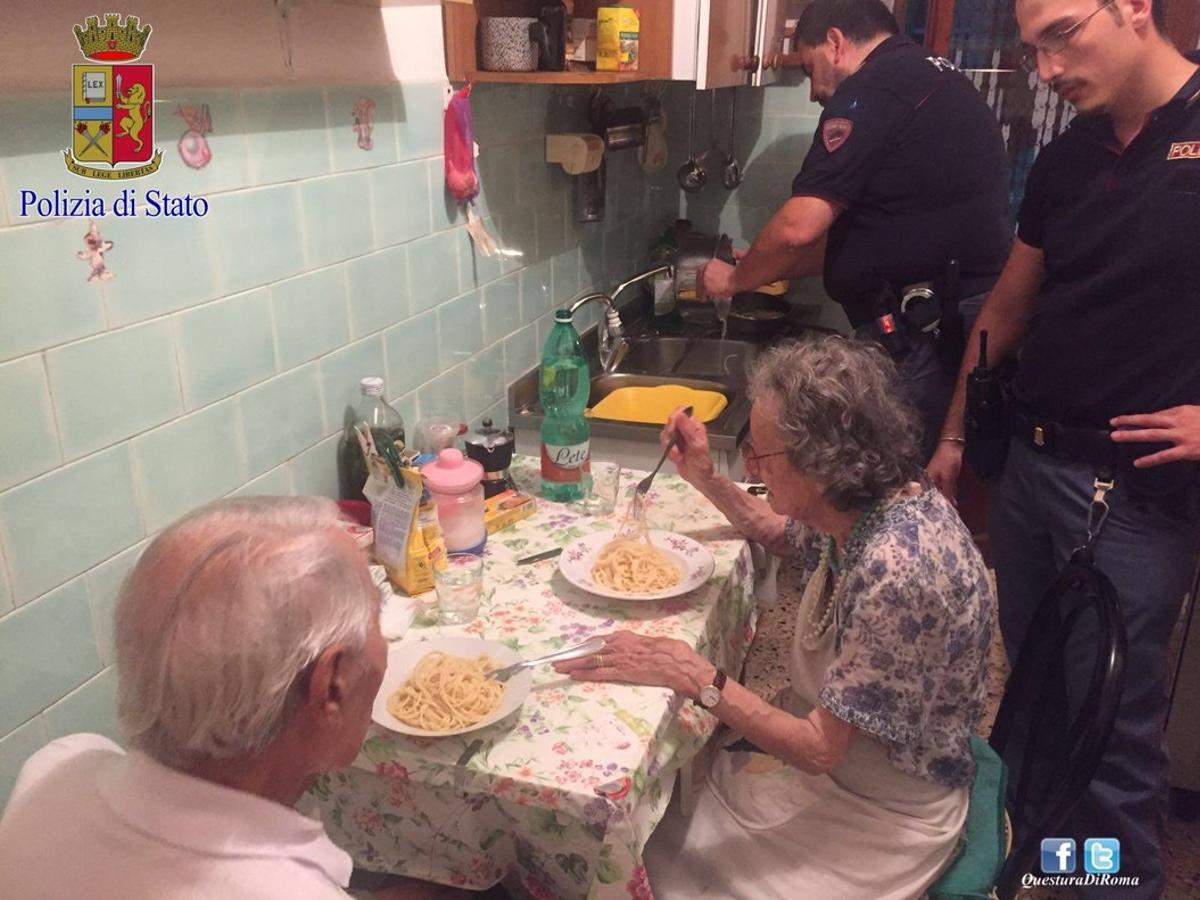 Michele, de espaldas, y Jole comen el plato de pasta que les han preparado los agentes de la policía de Roma.