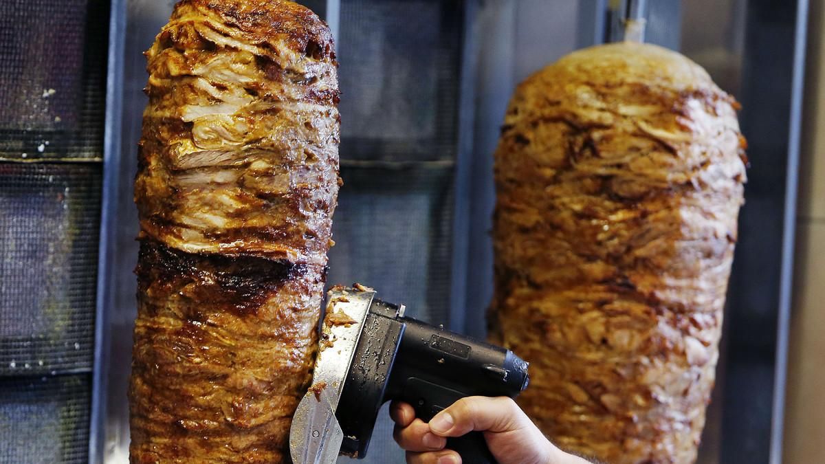 Un hombre corta carne de kebab en un establecimiento de Fráncfort. Un hombre corta carne de kebab en un establecimiento de Fráncfort.