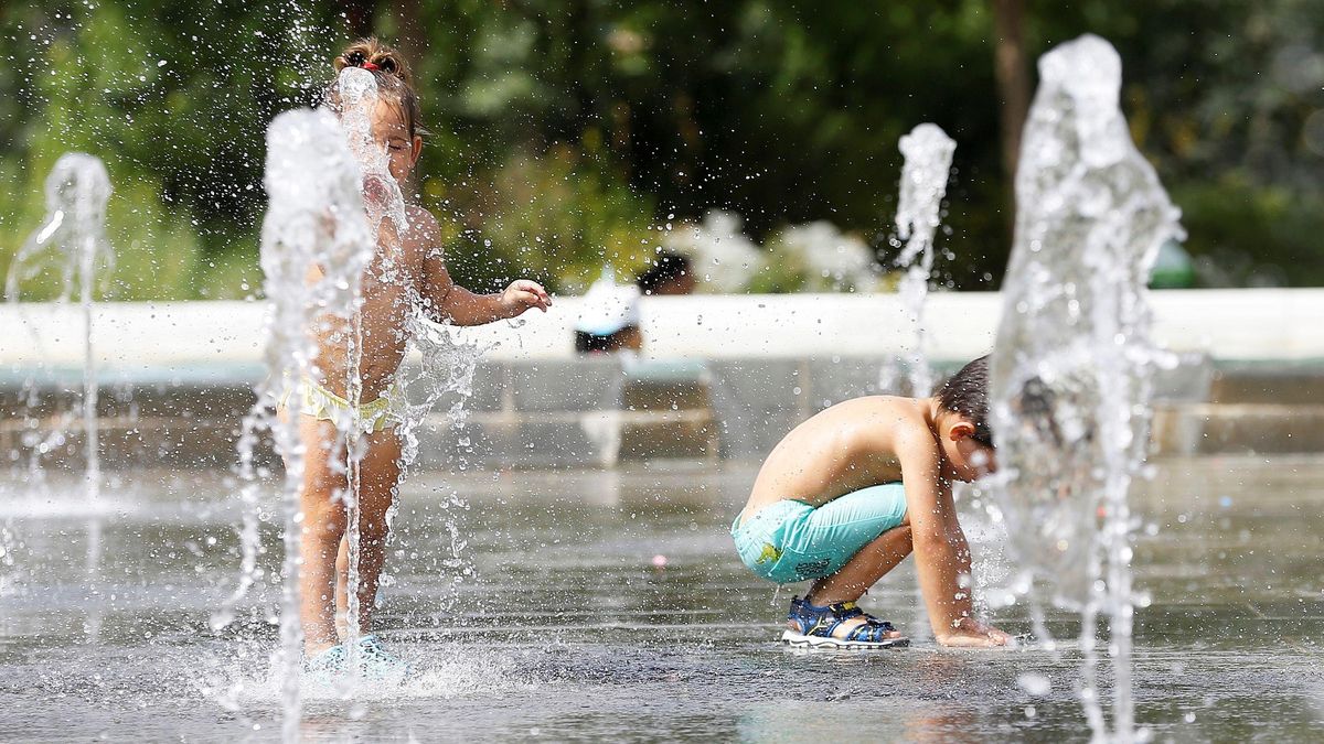Dos niños juegan en unas fuentes del Parque Central de Valencia para mitigar el intenso calor de este viernes Dos niños juegan en unas fuentes del Parque Central de Valencia para mitigar el intenso calor de este viernes