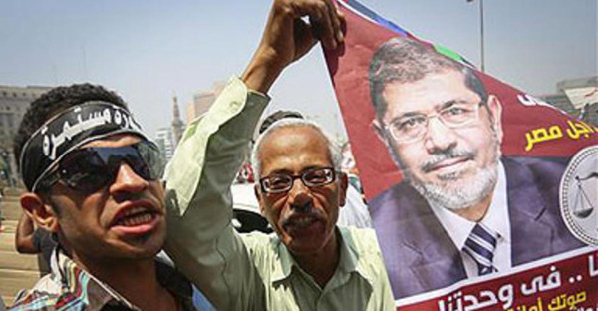 Dos simpatizantes de los Hermanos Musulmanes, Mohamed Mursi, sujetan un cartel electoral en la celebración en Tahrir, este lunes.
