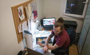 Un joven ilustrador teletrabaja desde su casa para un estudio de diseño gráfico en Barcelona.
