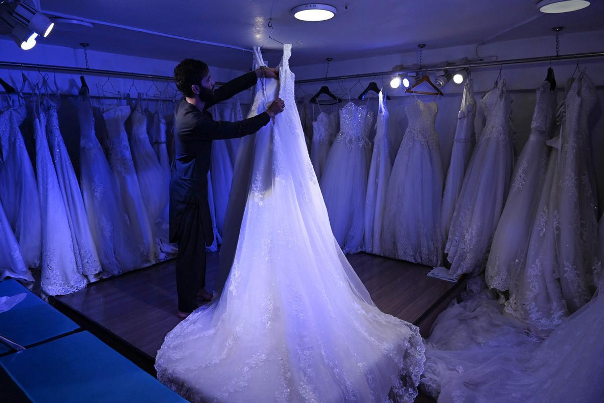 Un dependiente arregla un vestido de novias en una tienda de Kabul, este jueves.