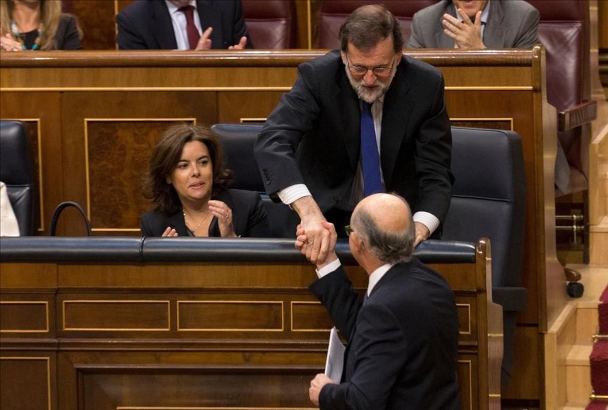 El presidente del Gobierno, Mariano Rajoy, saluda al ministro de Hacienda, Cristóbal Montoro, durante la tramitación de los Presupuestos del 2017, en mayo. 