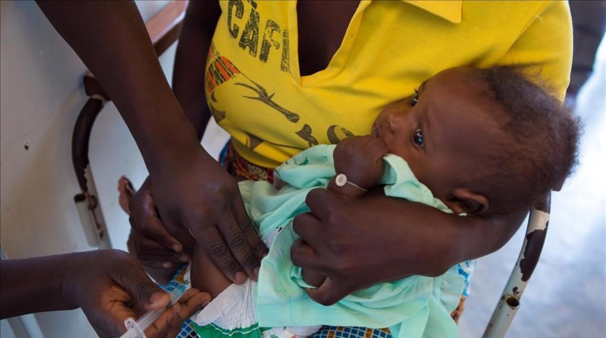 Un técnico sanitario vacuna a un bebé en Hindane (Mozambique).