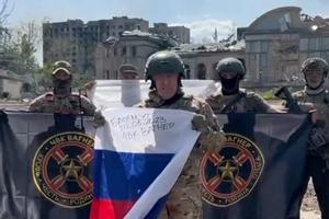 Captura de vídeo del líder de Wagner, Yevgueni Prigozhin, con una bandera rusa y banderas de Wagner en manos de sus mercenarios, en Bajmut.