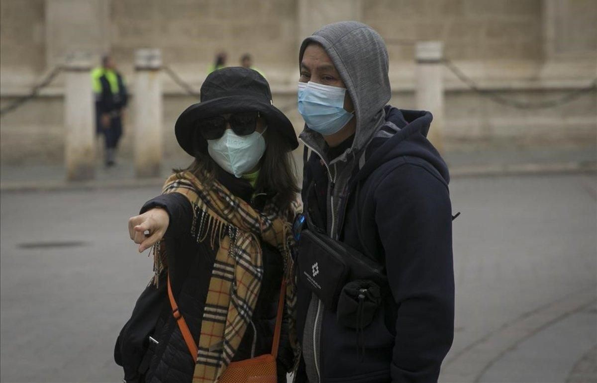 Turistas con mascarillas para protegerse del coronavirus pasean por Sevilla. Turistas con mascarillas para protegerse del coronavirus pasean por Sevilla.
