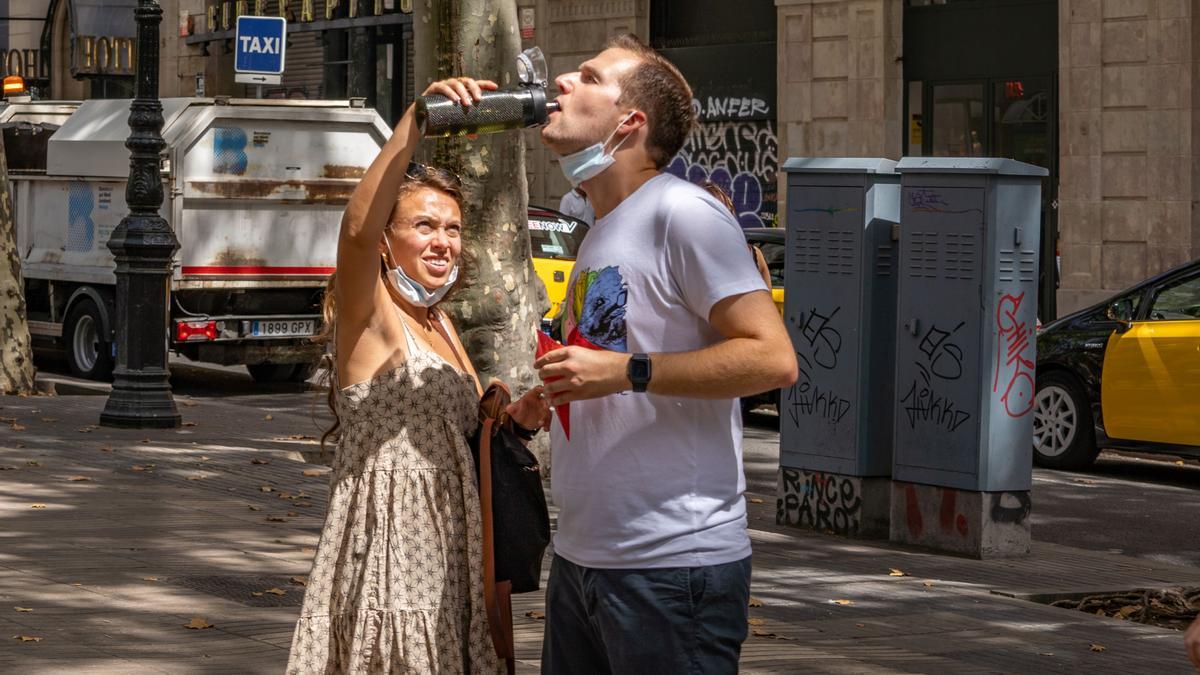 Dos turistas tomando agua por la ola de calor 