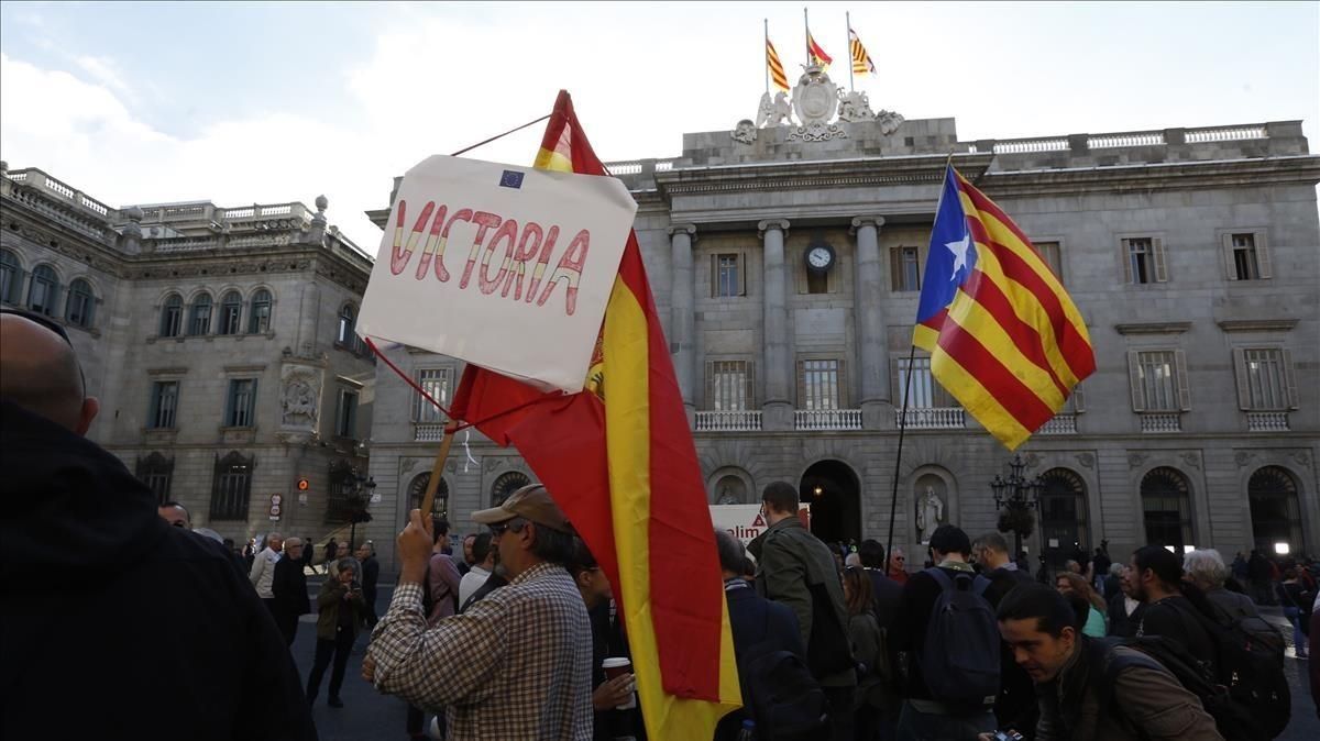 Un manifestante con una estelada y otro con una bandera española en la plaza de Sant Jaume. Un manifestante con una estelada y otro con una bandera española en la plaza de Sant Jaume.