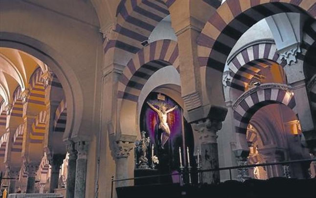 Interior de la mezquita-catedral de Córdoba, con un altar presidido por un gran crucifijo y una virgen de plata. Interior de la mezquita-catedral de Córdoba, con un altar presidido por un gran crucifijo y una virgen de plata.