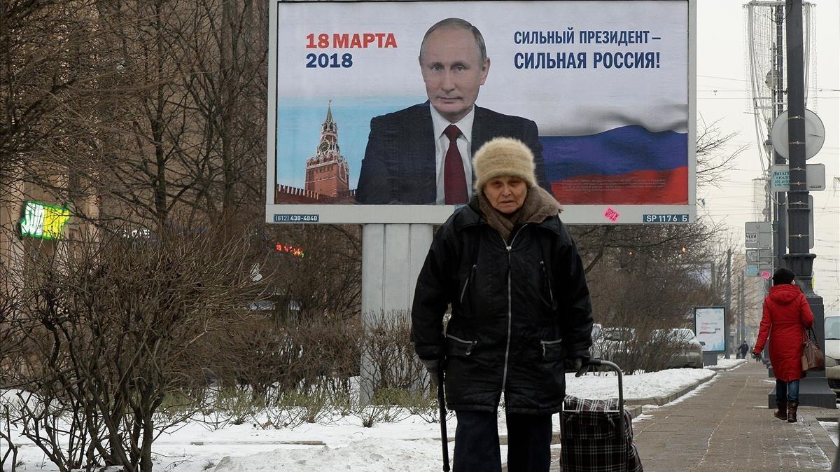 Una mujer pasa ante un espacio publicitario con la imagen de Putin y la leyenda ’Un presidente fuerte es un país fuerte’, en San Petersburgo, el 12 de enero.