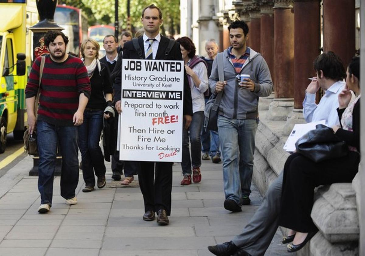 Un licenciado universitario en paro lleva una pancarta en la que pide trabajo, en Londres. Un licenciado universitario en paro lleva una pancarta en la que pide trabajo, en Londres.