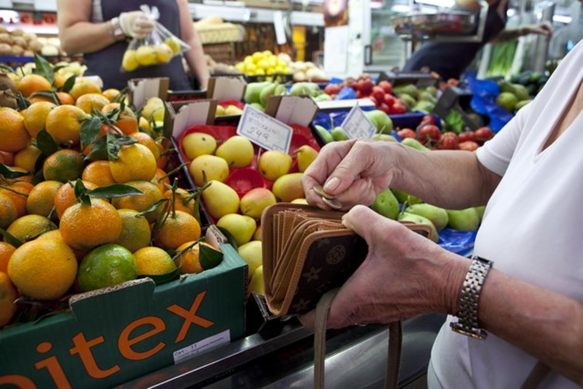 Una dona omple un cistell en un mercat de Barcelona.