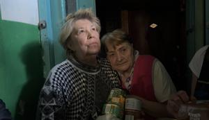 Dos mujeres reciben ayuda de voluntarios en Járkov (Ucrania).