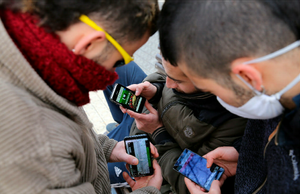 Varios jóvenes miran sus móviles