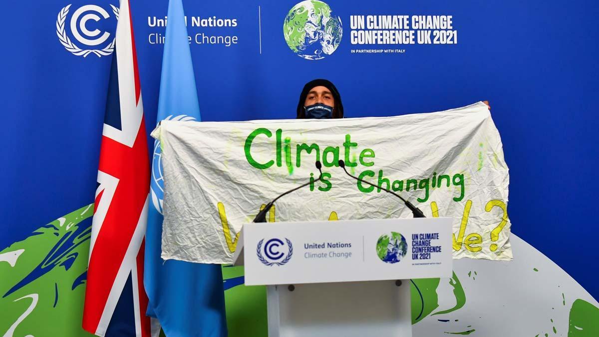 Un activista muestra una pancarta durante la cumbre del clima COP26 de Glasgow.