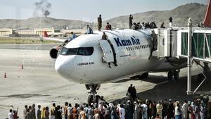 Afganos subidos en un avión mientras esperan en el aeropuerto de Kabul.