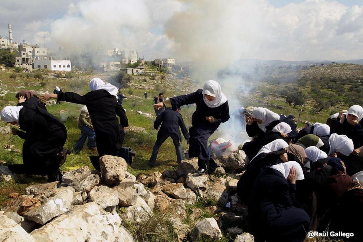 Un grupo de mujeres palestinas trata de escapar de los gases lacrimógenos lanzados por soldados israelís durante una protesta en contra de la construcción del muro de seguridad. Deir Qaddis, Cisjordania. 2004. Fotografía del reportaje ’La intifada del muro’.
