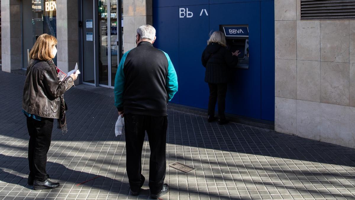 Jubilados hacen cola en un cajero para retirar dinero de una entidad bancaria.