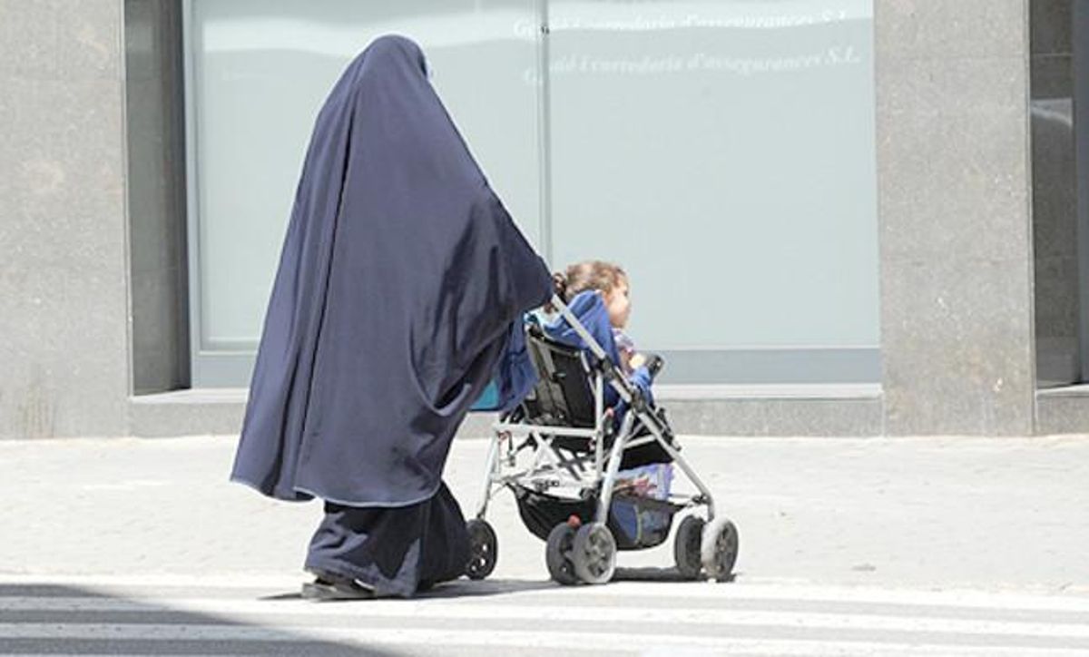 Una mujer con burka pasea con su hijo. Una mujer con burka pasea con su hijo.