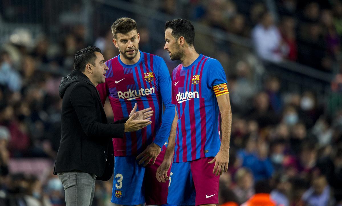 Xavi se dirige a Piqué y Busquets en la banda durante el partido de liga entre el FC Barcelona y el RCD Espanyol en el Camp Nou, en noviembre de 2021.
