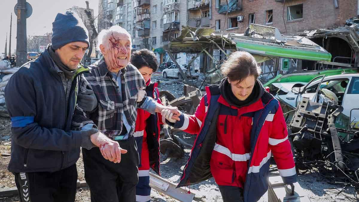Al menos dos muertos en un nuevo ataque nocturno en una zona residencial de Kiev. Médicos y ciudadanos ayudan a un hombre herido durante un bombardeo en la ciudad.