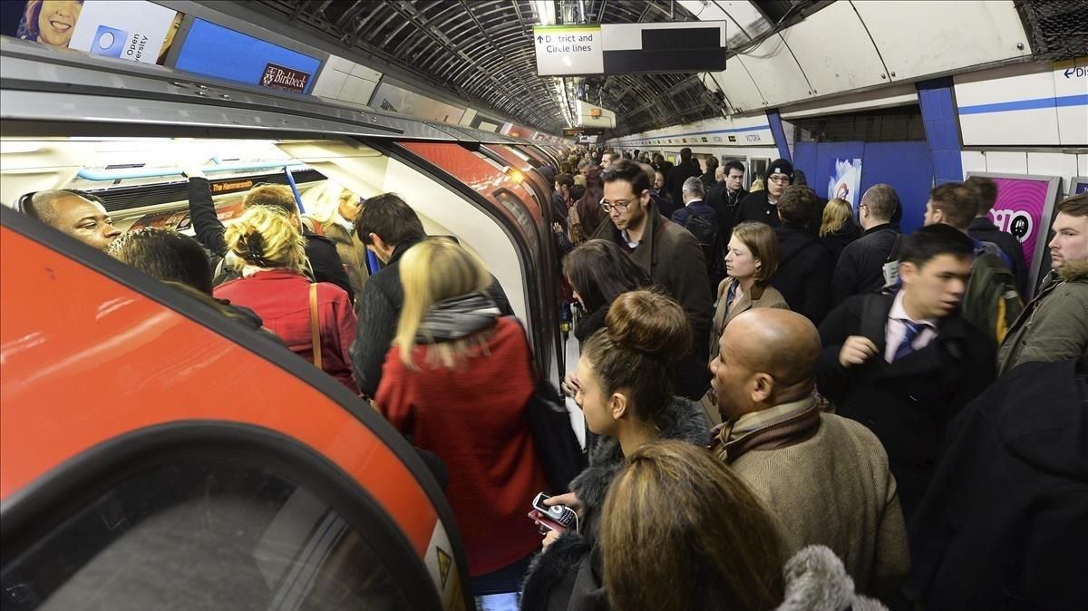 Una multitud de pasajeros espera para entrar en el metro de Londres Una multitud de pasajeros espera para entrar en el metro de Londres