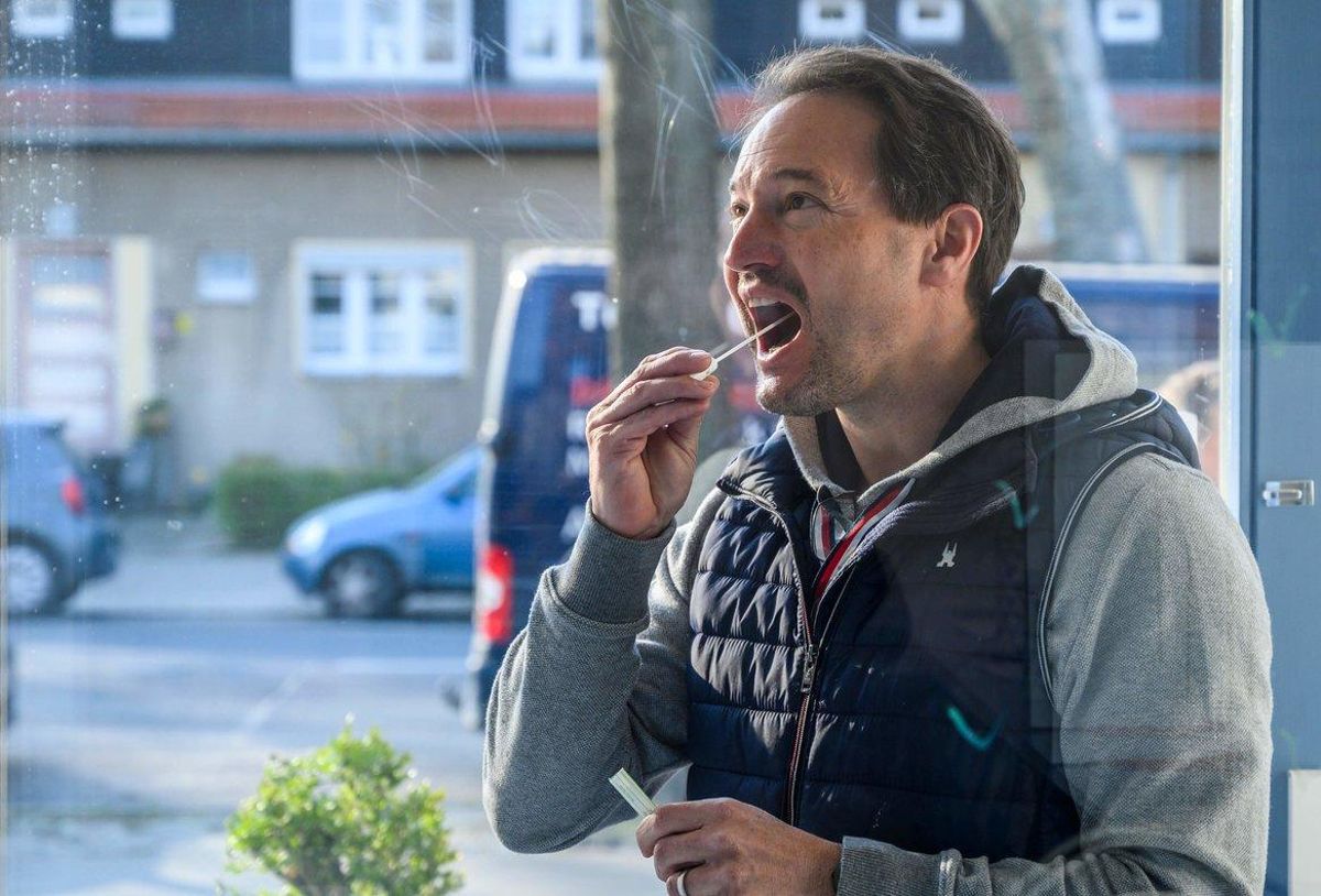 Un hombre se coge una muestra de saliva para hacerse el test de coronavirus. Un hombre se coge una muestra de saliva para hacerse el test de coronavirus.