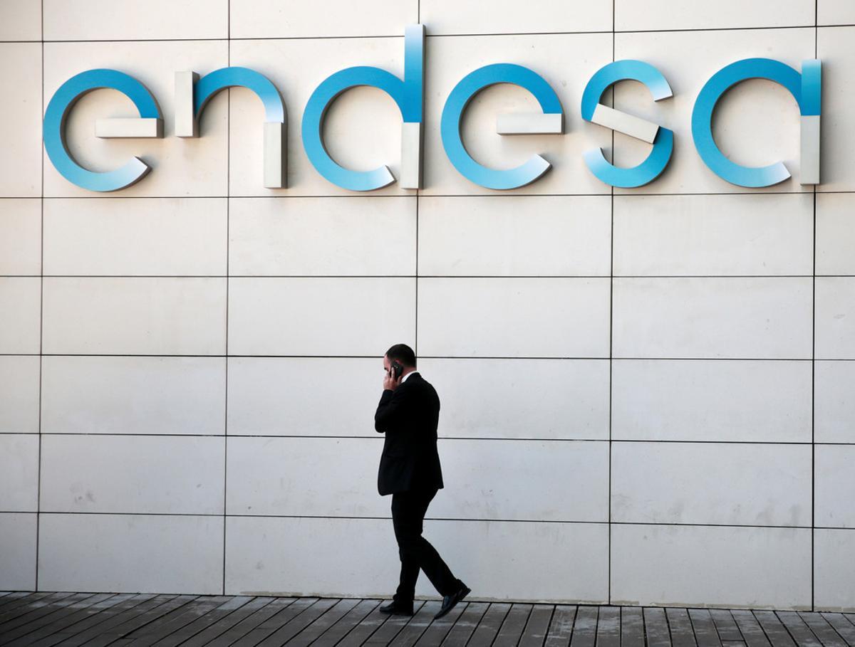 Un hombre camina bajo el logo de Endesa en la sede de la empresa en Madrid 