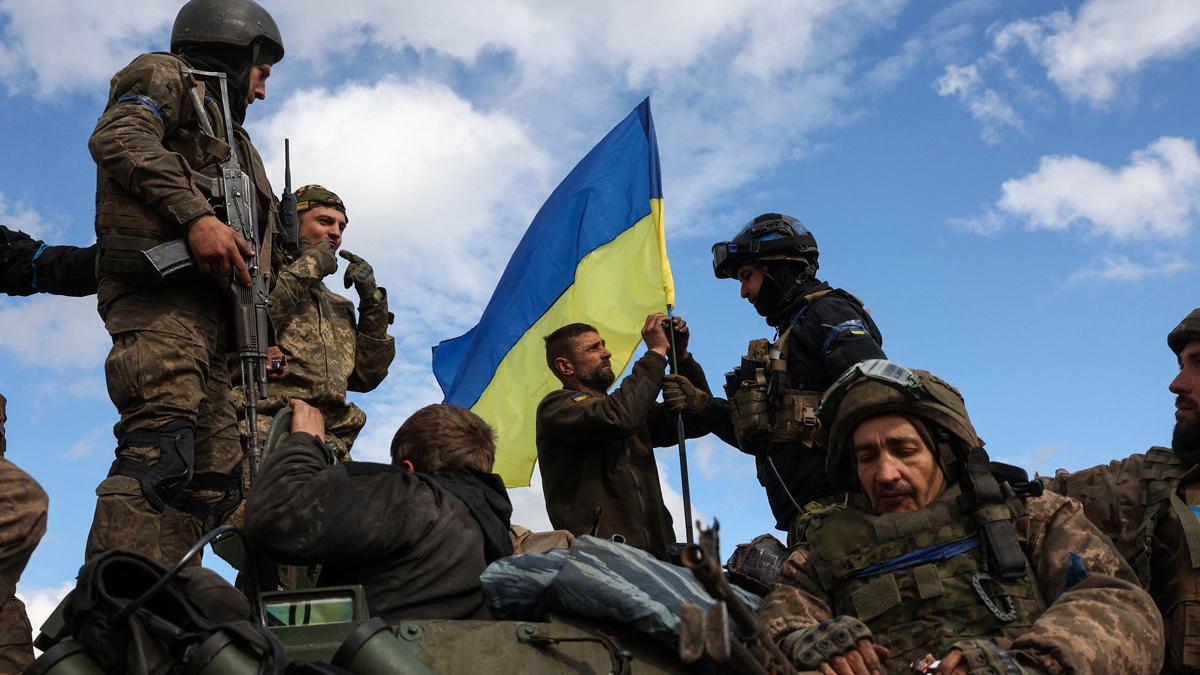 Soldados ucranianos colocan una bandera de su país en un vehículo armado cerca de Lyman, en la región de Donetsk.