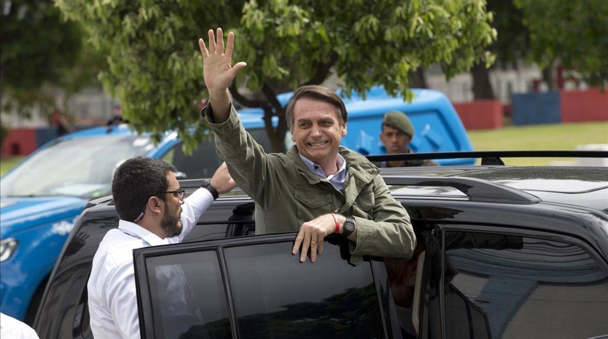 Bolsonaro saluda a sus seguidores tras depositar su voto.