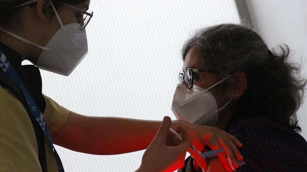 Una mujer del Servicio Gallego de Salud (Sergas) vacuna a las primeras personas de entre 50 y 55 con las dosis de AstraZeneca, este jueves. Una mujer del Servicio Gallego de Salud (Sergas) vacuna a las primeras personas de entre 50 y 55 con las dosis de AstraZeneca, este jueves.