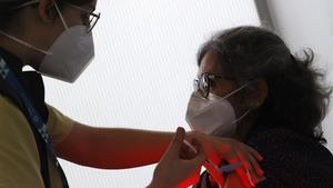 Una mujer del Servicio Gallego de Salud (Sergas) vacuna a las primeras personas de entre 50 y 55 con las dosis de AstraZeneca, este jueves.