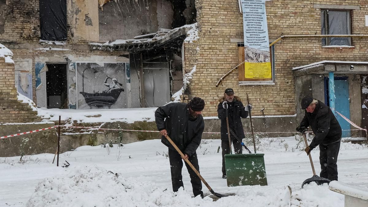 Residentes de la población ucraniana de Horenka quitan nieve junto a un edificio destruido, en el que se aprecia un grafiti de Banksy. Residentes de la población ucraniana de Horenka quitan nieve junto a un edificio destruido, en el que se aprecia un grafiti de Banksy.