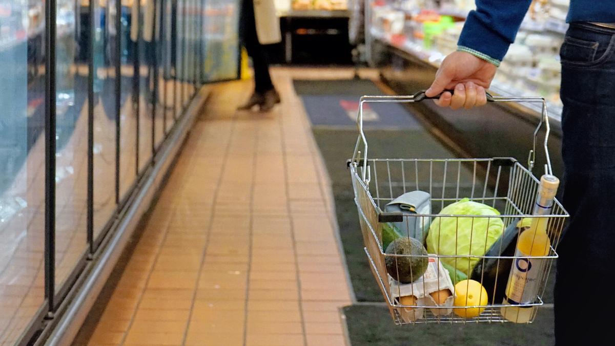 Un consumidor adquiere productos en un supermercado.