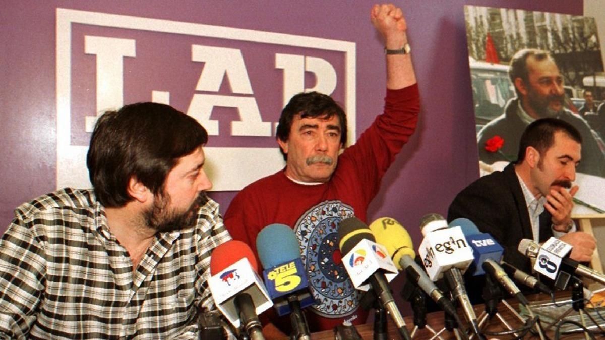 Paco, hermano de Eugenio Aranburu, saluda puño en alto al inicio de la rueda de prensa del sindicato LAB junto a Rafa Diez i y Txutxi Ariznabarreta, en febrero de 1997. Paco, hermano de Eugenio Aranburu, saluda puño en alto al inicio de la rueda de prensa del sindicato LAB junto a Rafa Diez i y Txutxi Ariznabarreta, en febrero de 1997.