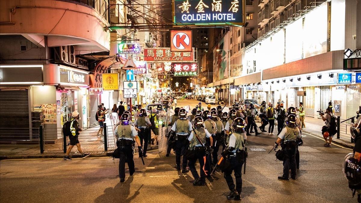 Un grupo de policías antidisturbios toma posición en una calle de Hong Kong. Un grupo de policías antidisturbios toma posición en una calle de Hong Kong.