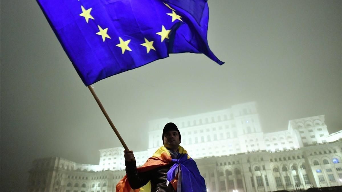 Un hombre enarbola la bandera europea frente al Parlamento rumano durante una protesta contra la corrupción, en noviembre del 2017 en Bucarest. Un hombre enarbola la bandera europea frente al Parlamento rumano durante una protesta contra la corrupción, en noviembre del 2017 en Bucarest.