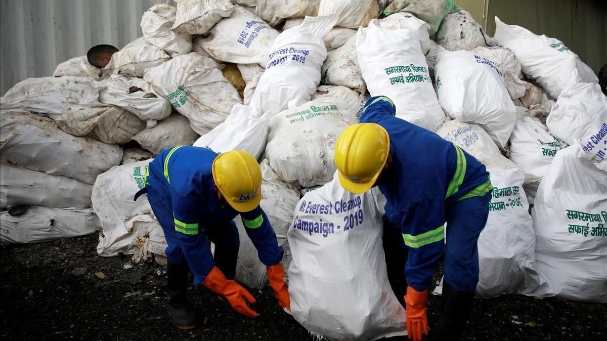 Empleados nepalís recogen basura recopilada en el Everest. Empleados nepalís recogen basura recopilada en el Everest.