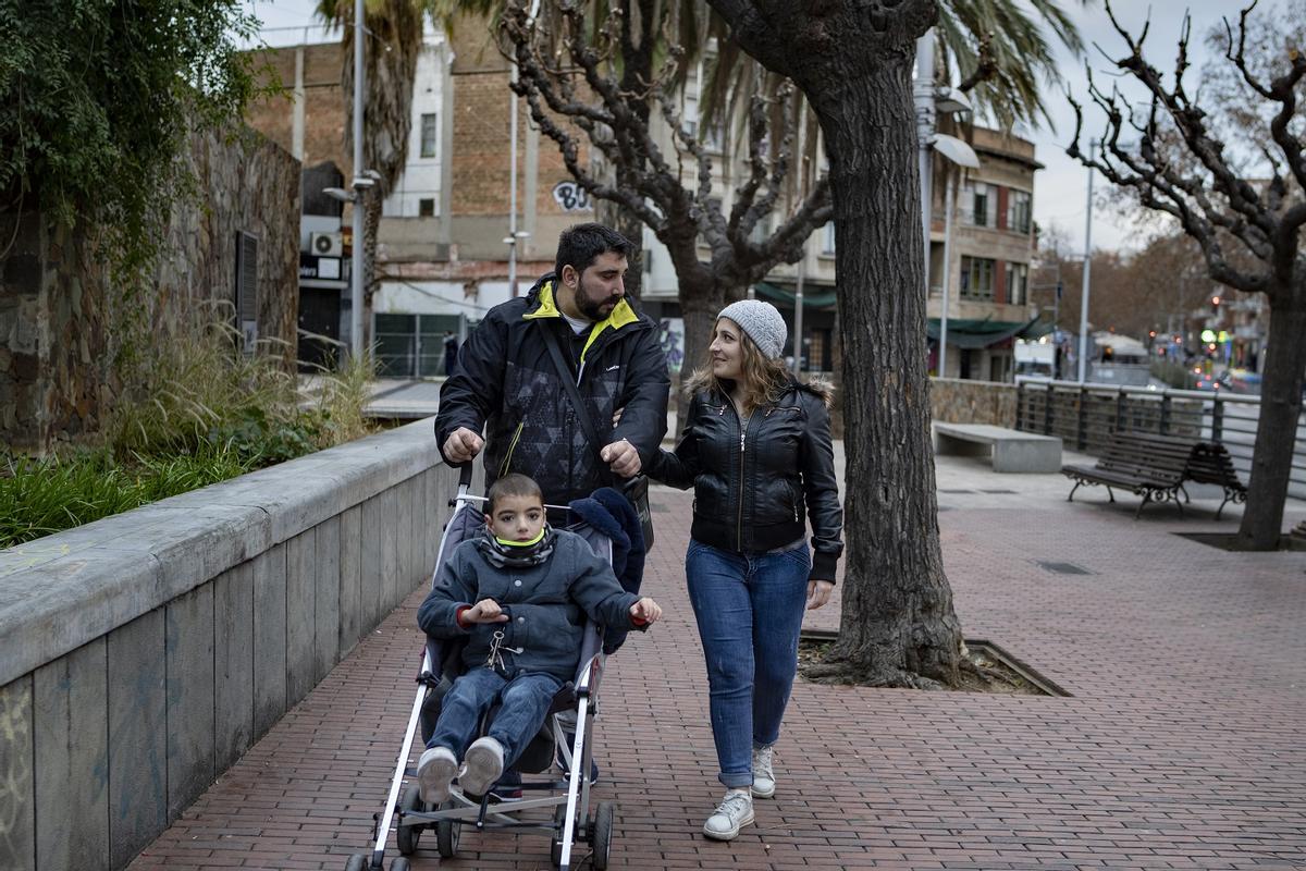 Íker, de 7 años y con el síndrome de KBG, junto a sus padres, Verónica Ramón y Juan Manuel Heredia, en una calle de Santa Coloma de Gramenet.