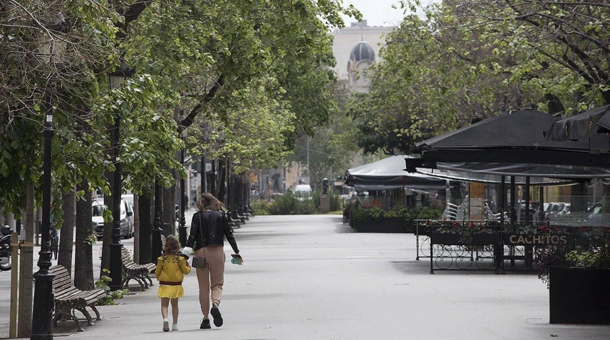 Una mujer camina con su hija por una Rambla de Catalunya desierta, el 23 de abril. Una mujer camina con su hija por una Rambla de Catalunya desierta, el 23 de abril.