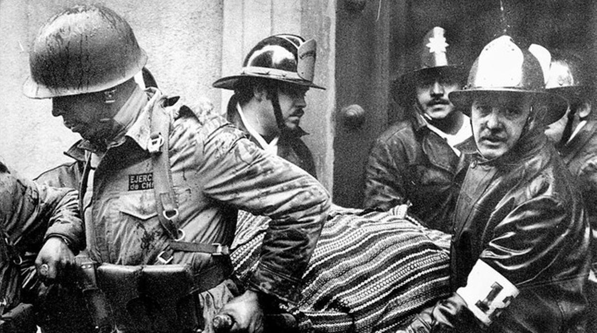 Soldados y bomberos sacan el cuerpo de Allende del palacio de la Moneda, el 11 de septiembre de 1973.