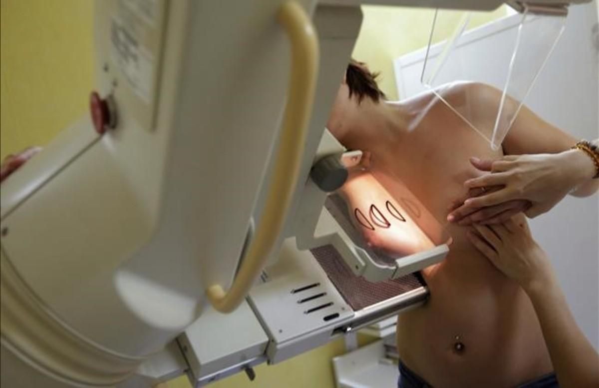 Una mujer se somete a una mamografía. Una mujer se somete a una mamografía.
