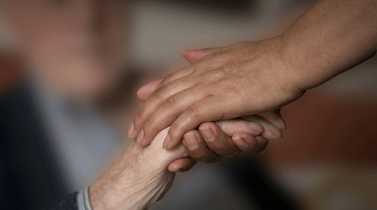 Una mujer coge la mano de una anciana, en una foto de archivo. Una mujer coge la mano de una anciana, en una foto de archivo.