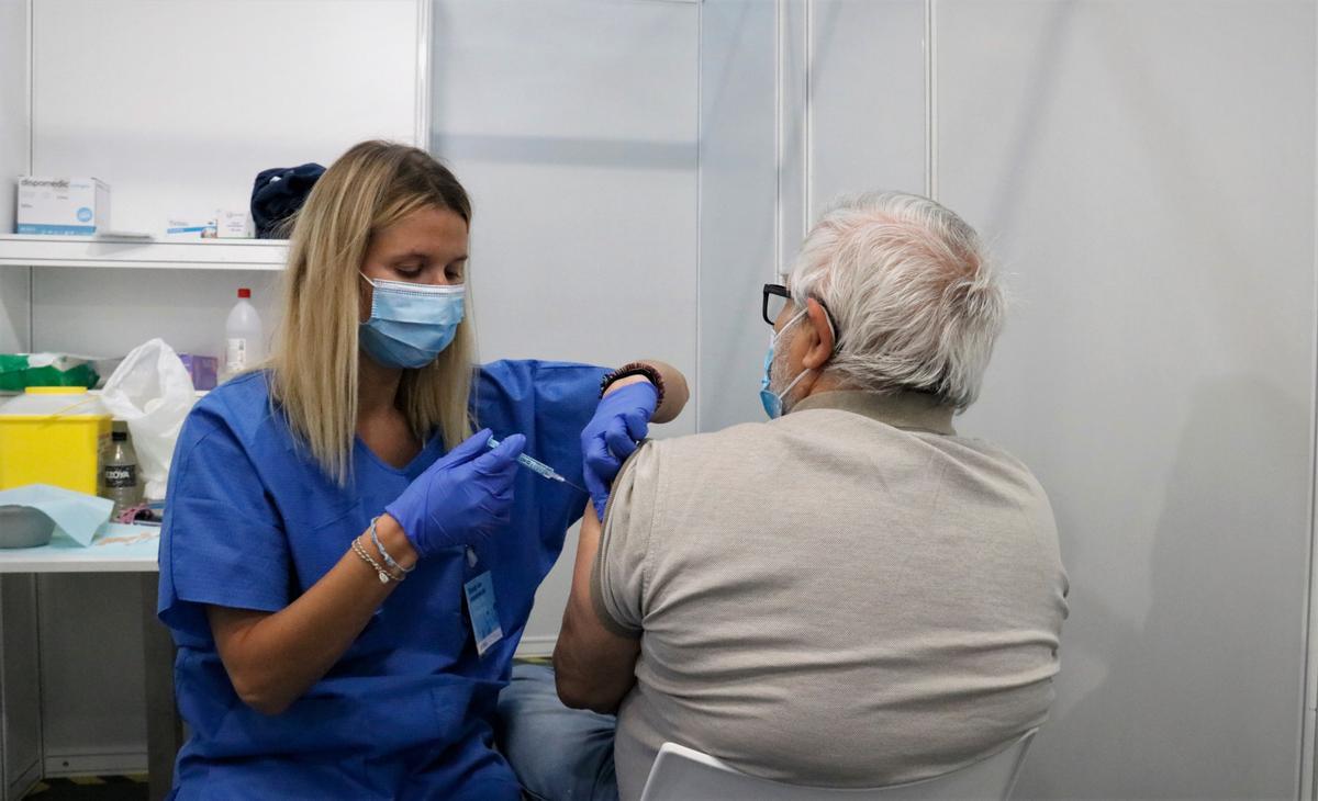Una enfermera vacuna a un hombre en uno de los box del punto de vacunación masiva habilitado en la Fira de Barcelona.