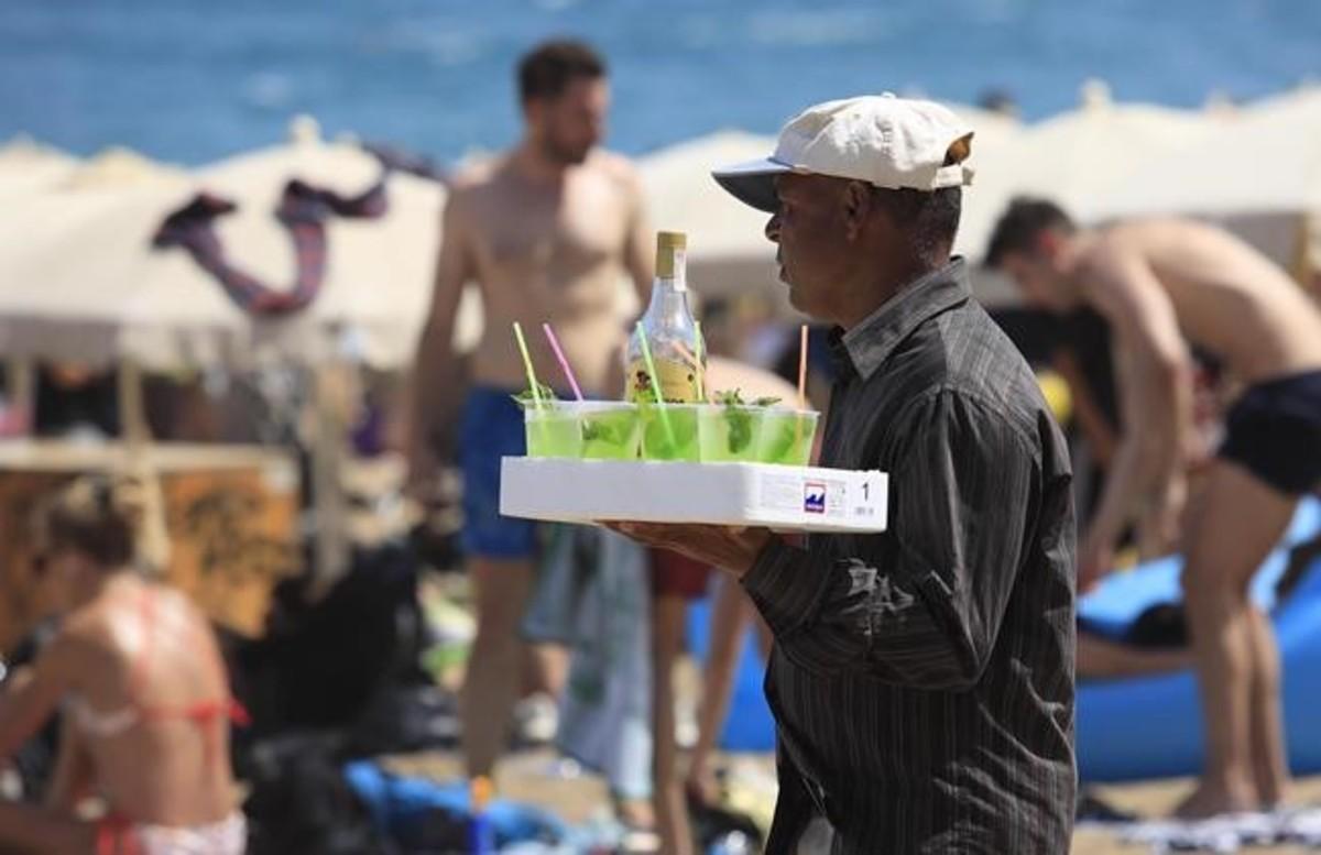 Un hombre vende mojitos en la Barceloneta. Un hombre vende mojitos en la Barceloneta.