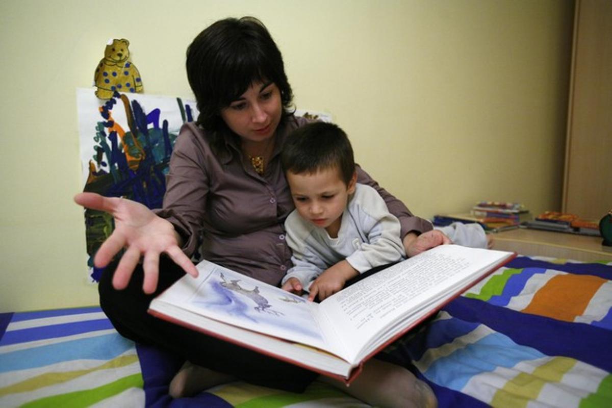 Una madre le lee un cuento a su hijo.